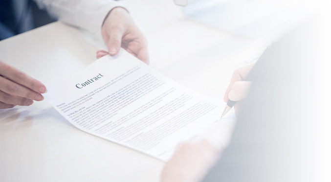 Two people signing a contract