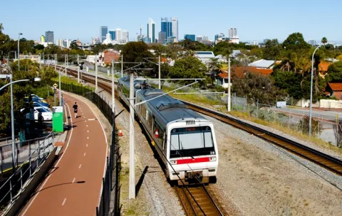 Train on train tracks, with Perth city in background