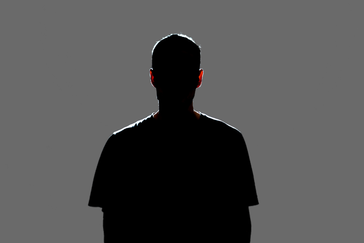 Man standing in silhouette with back to camera. 